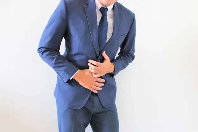 腹部を押さえる男性
