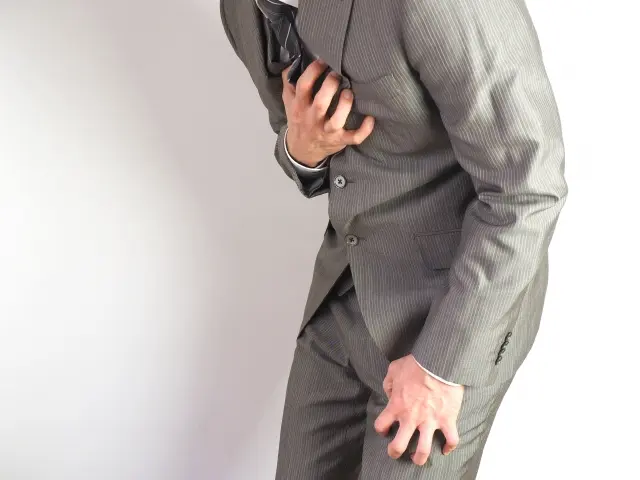 胸を押さえる男性